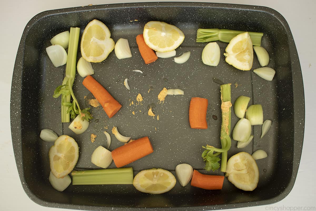 Carrots, celery, onion and lemon wedges added to roasting pan.