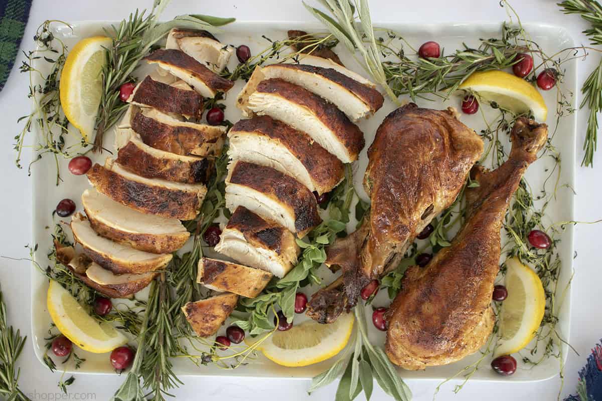 Platter with carved turkey breast and legs.