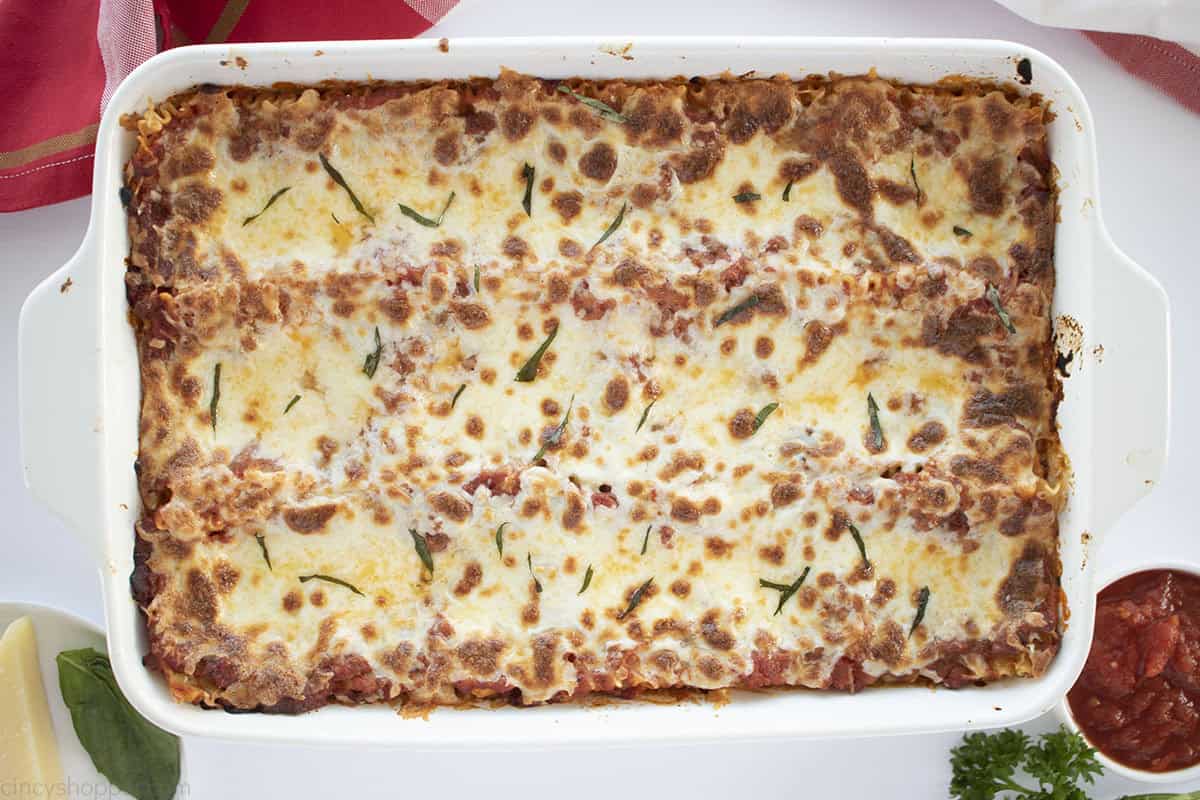 Homemade baked lasagna with golden melted cheese in casserole dish.