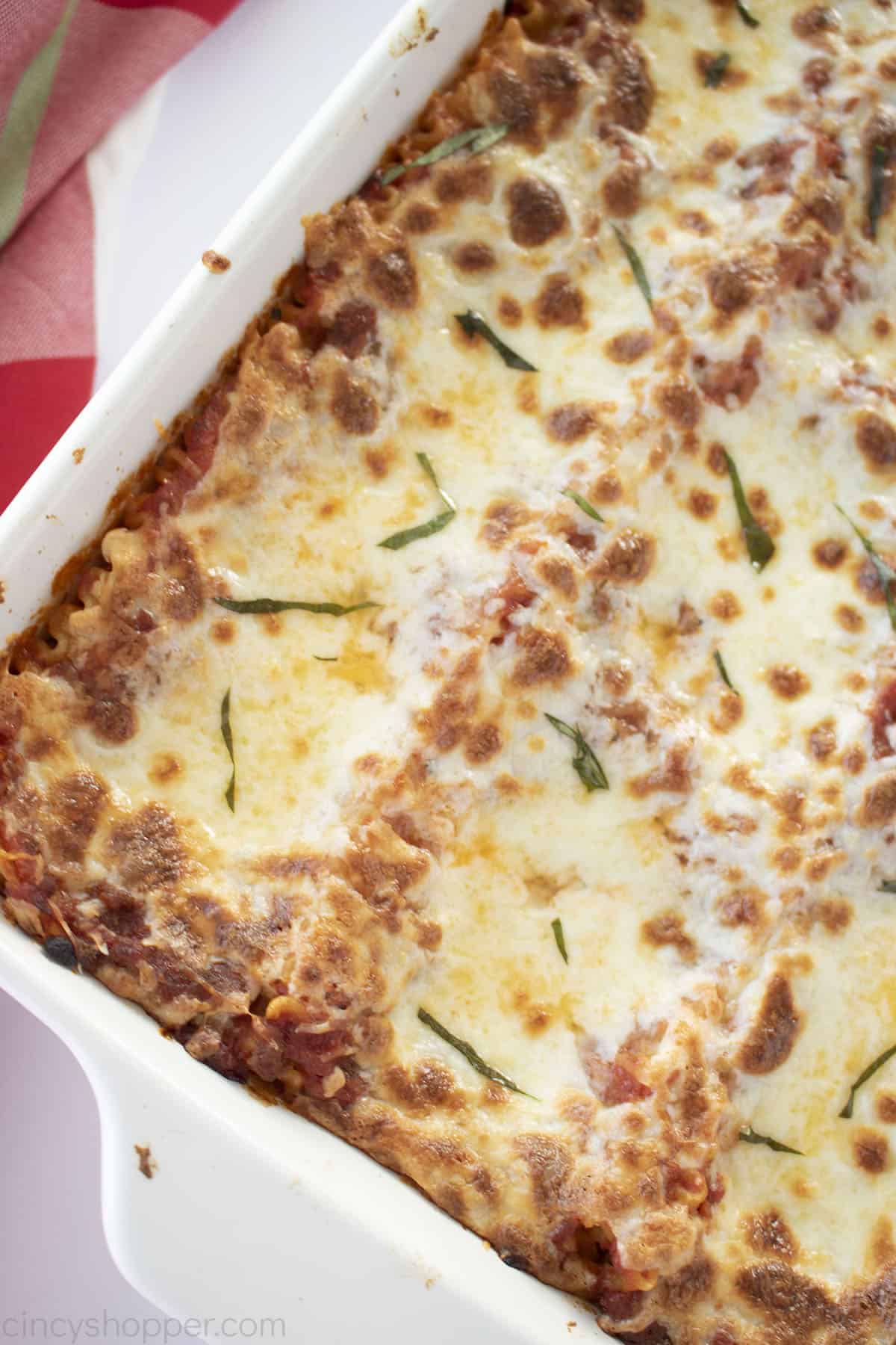 Overhead of lasagna in a white casserole dish.
