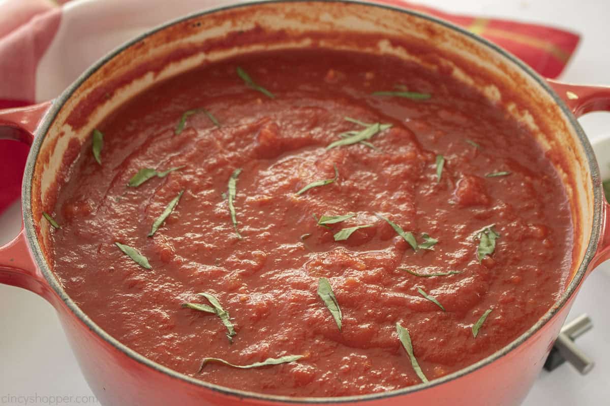 Fresh cooked marinara sauce in a red pot.