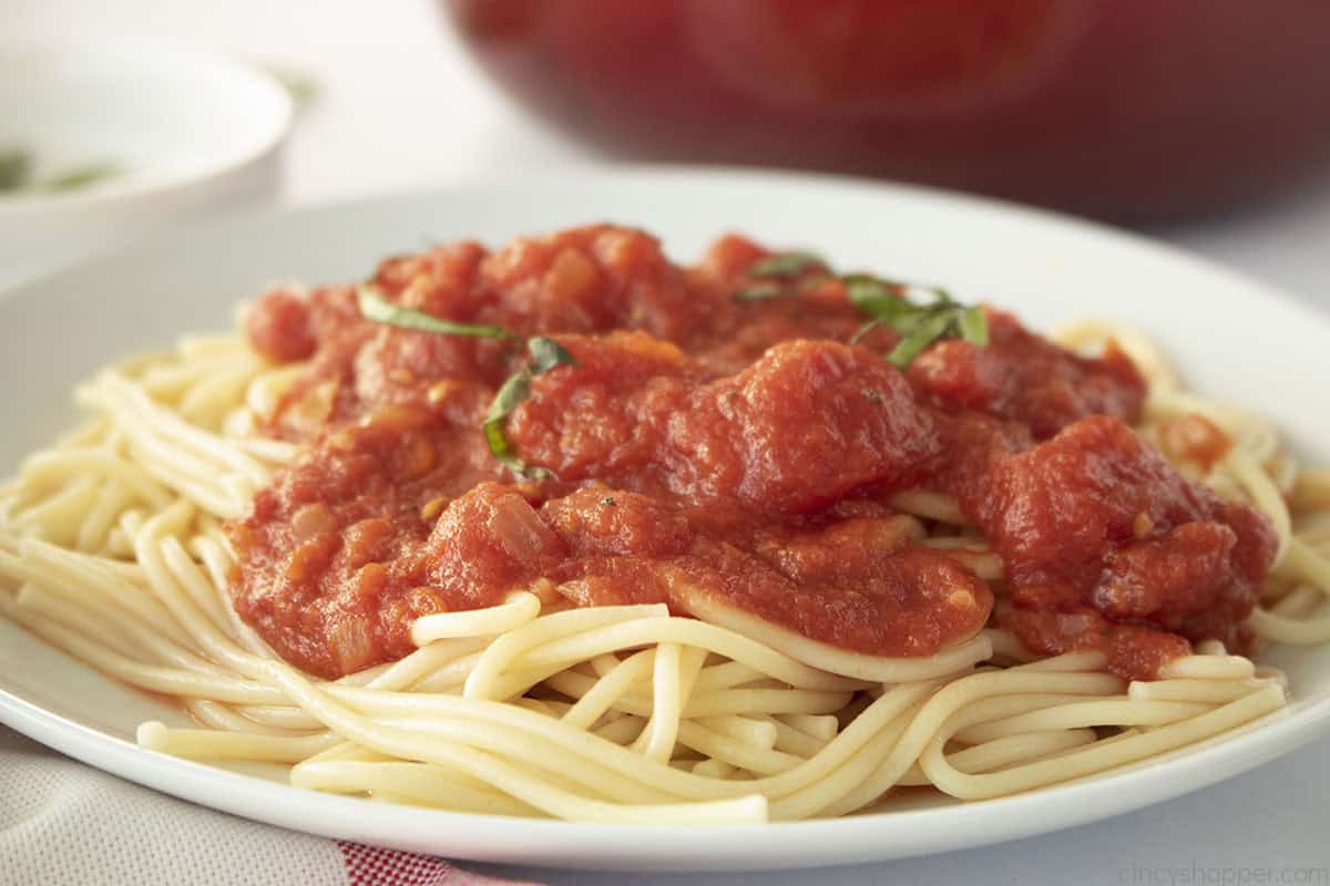Plate of spaghetti topped with homemade marinara sauce.