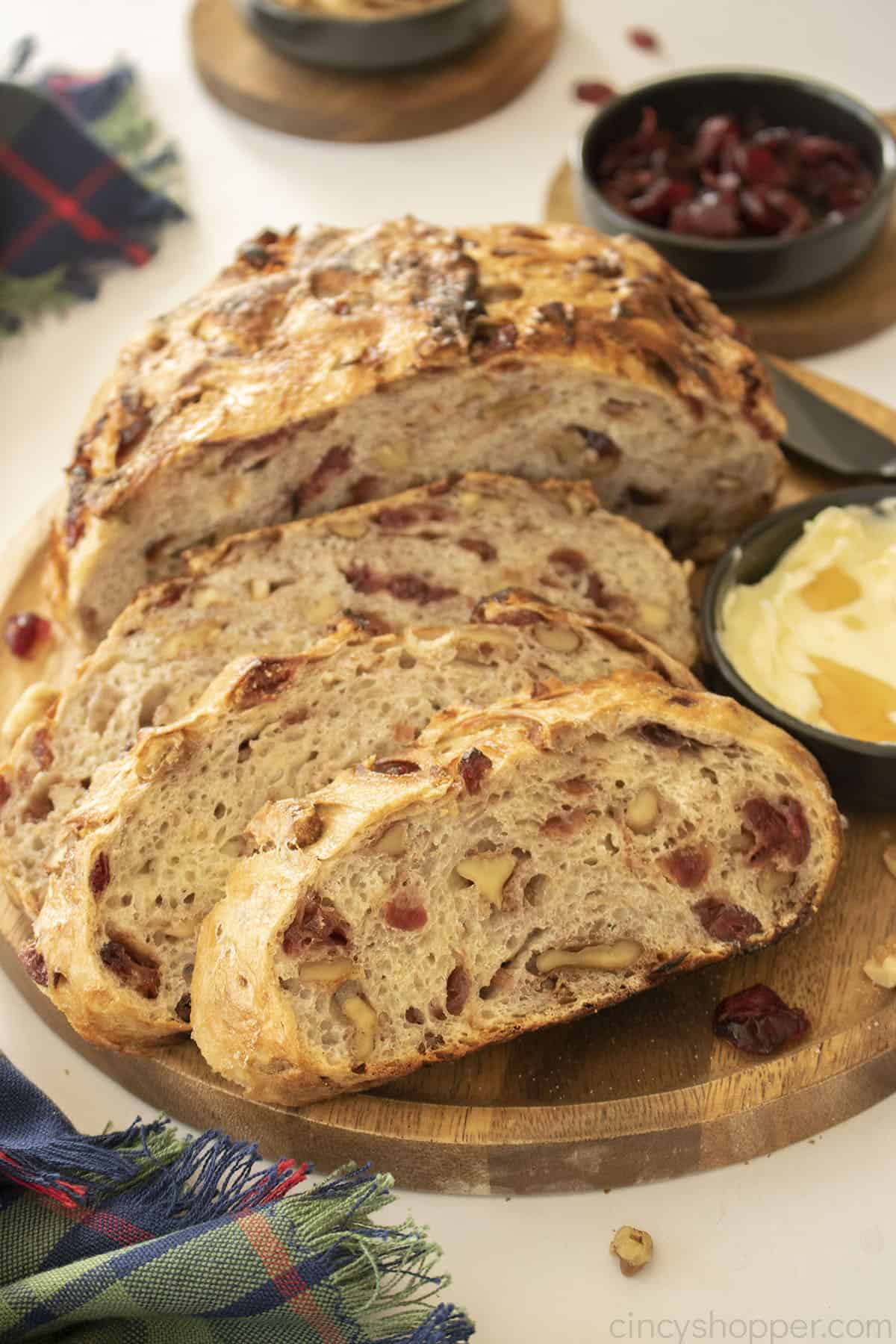 Slices of Cranberry walnut bread on a wood platter.