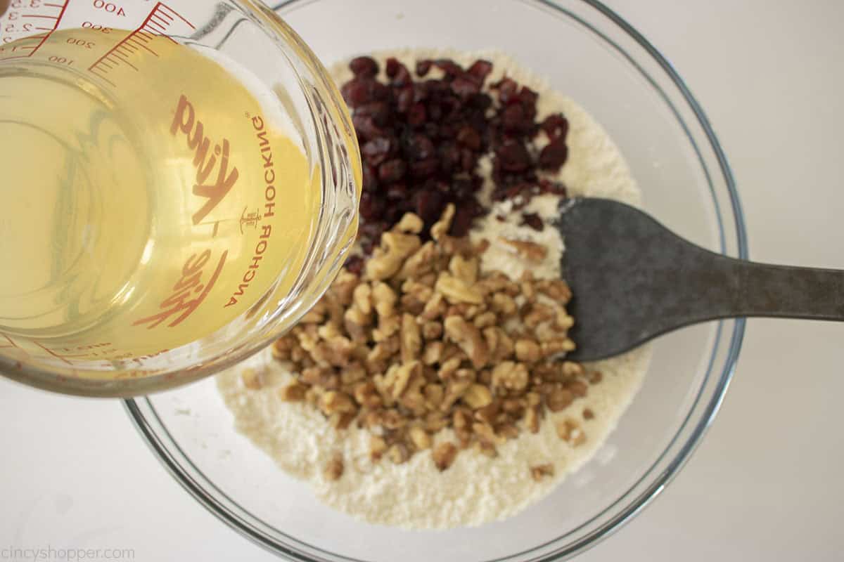 Honey water added to flour, cranberry and nut mixture.