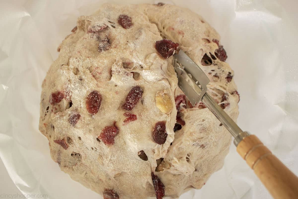 Lame slicing the cranberry nut bread dough after rise.