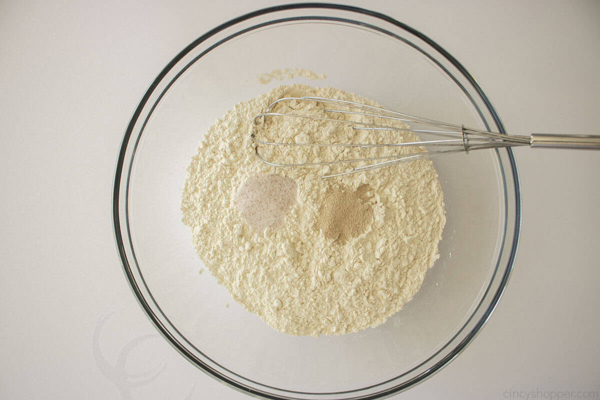 Flour, yeast and salt in a clear mixing bowl with whicsk.