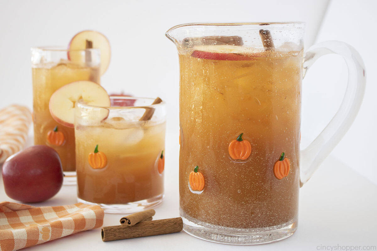 Two glasses and a pitcher filled with Thanksgiving Punch.