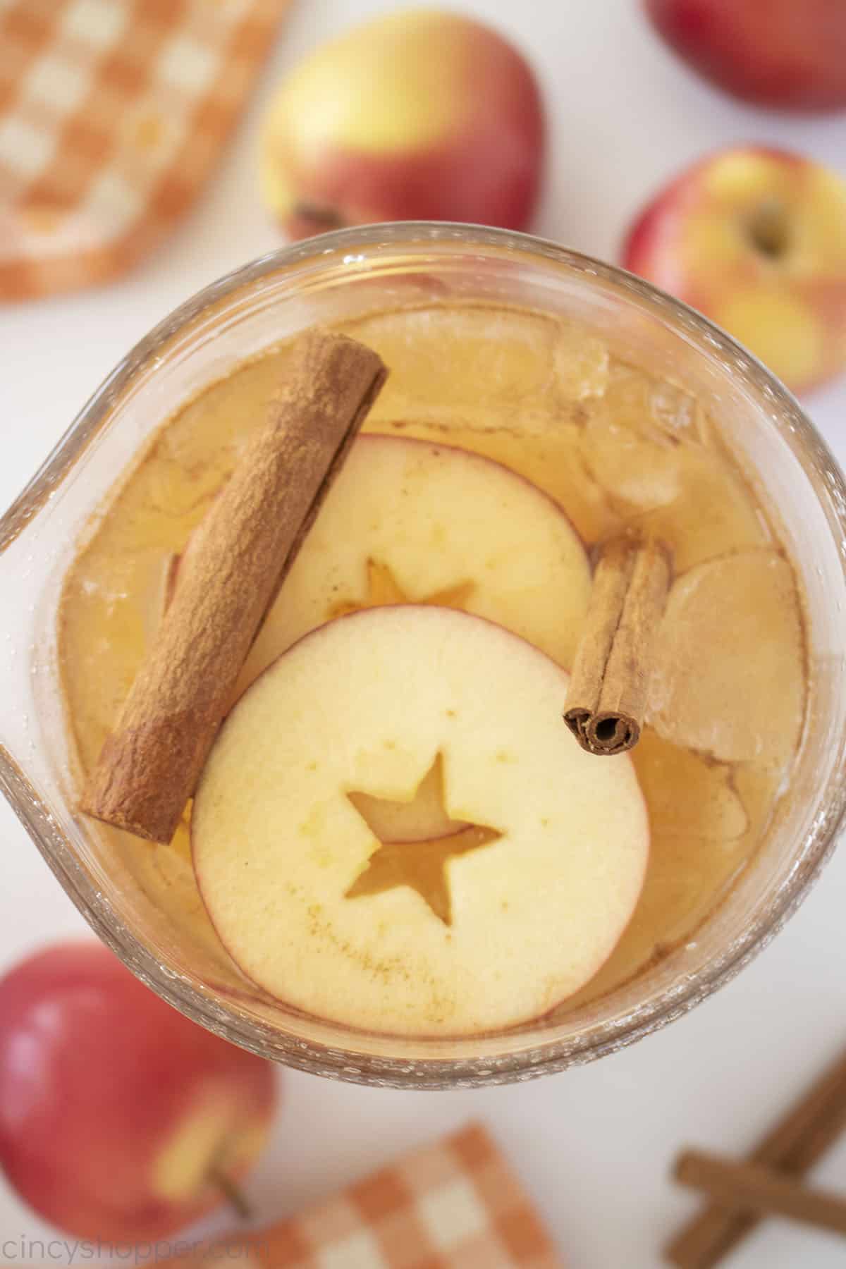 Overhead closeup of Thanksgiving Punch in a Pitcher with sliced apples,  apples and cinnamon sticks