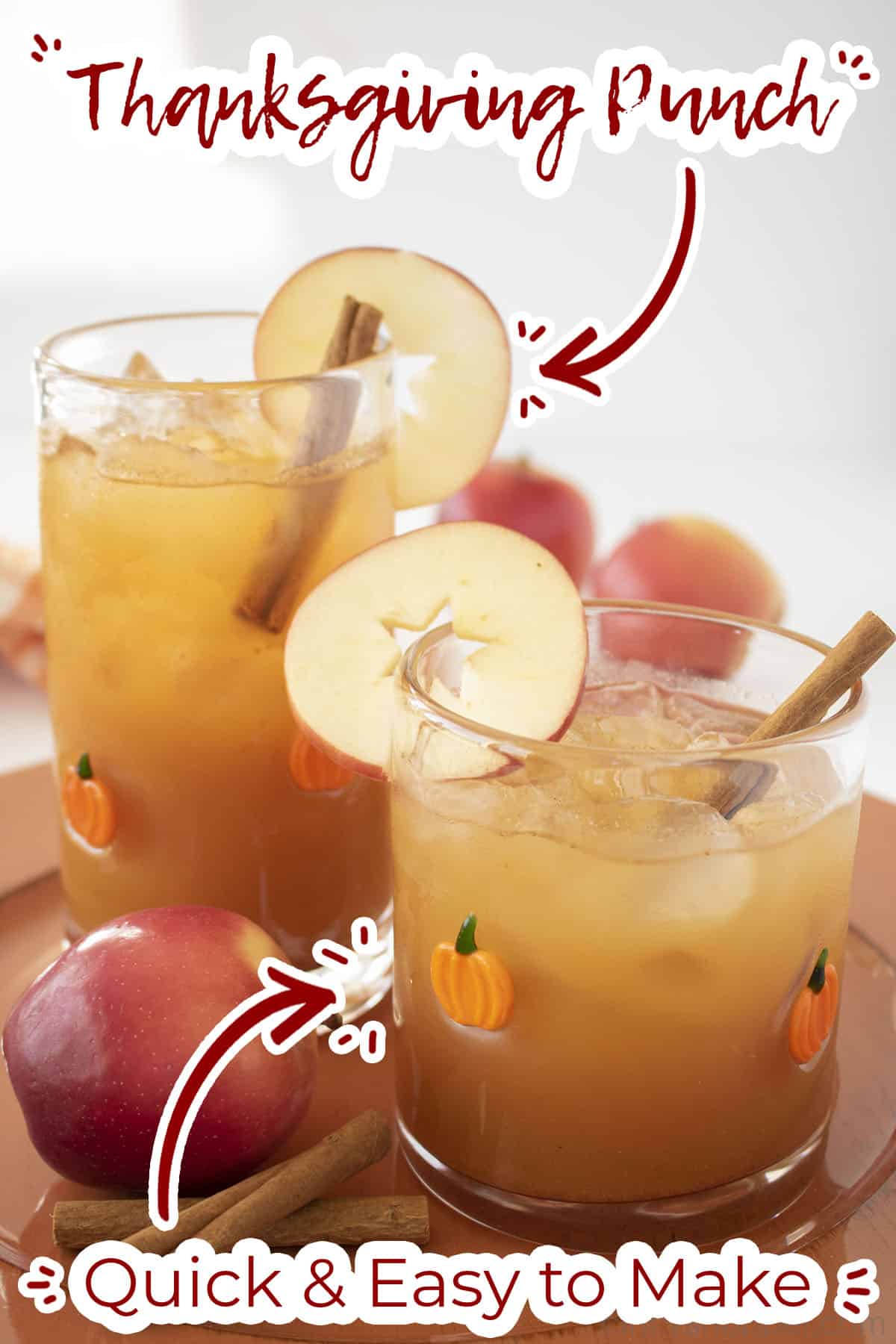 Fall punch in two glasses with apples and cinnamon sticks.