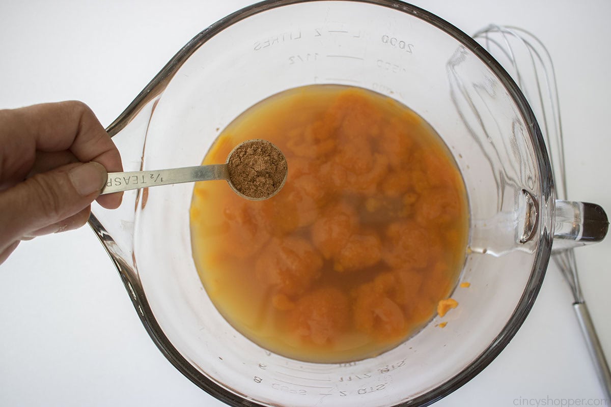 Adding pumpkin pie spice to the pumpkin caramel apple cider mixture.