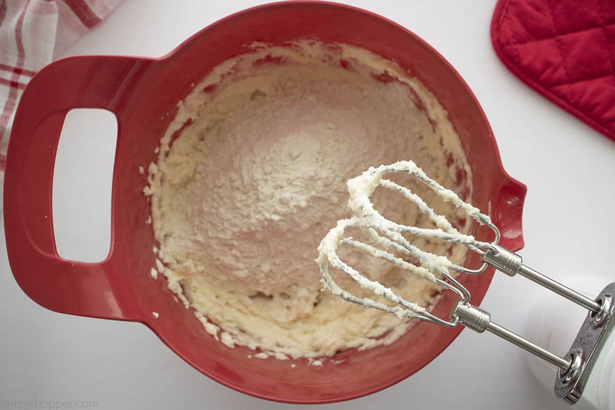 Adding flour to butter and sugar mixture.