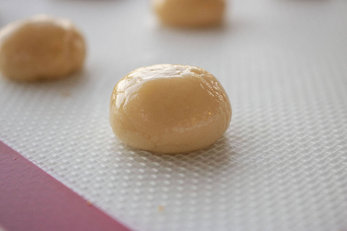 Anise cookie dough ball on a lined cookie sheet.