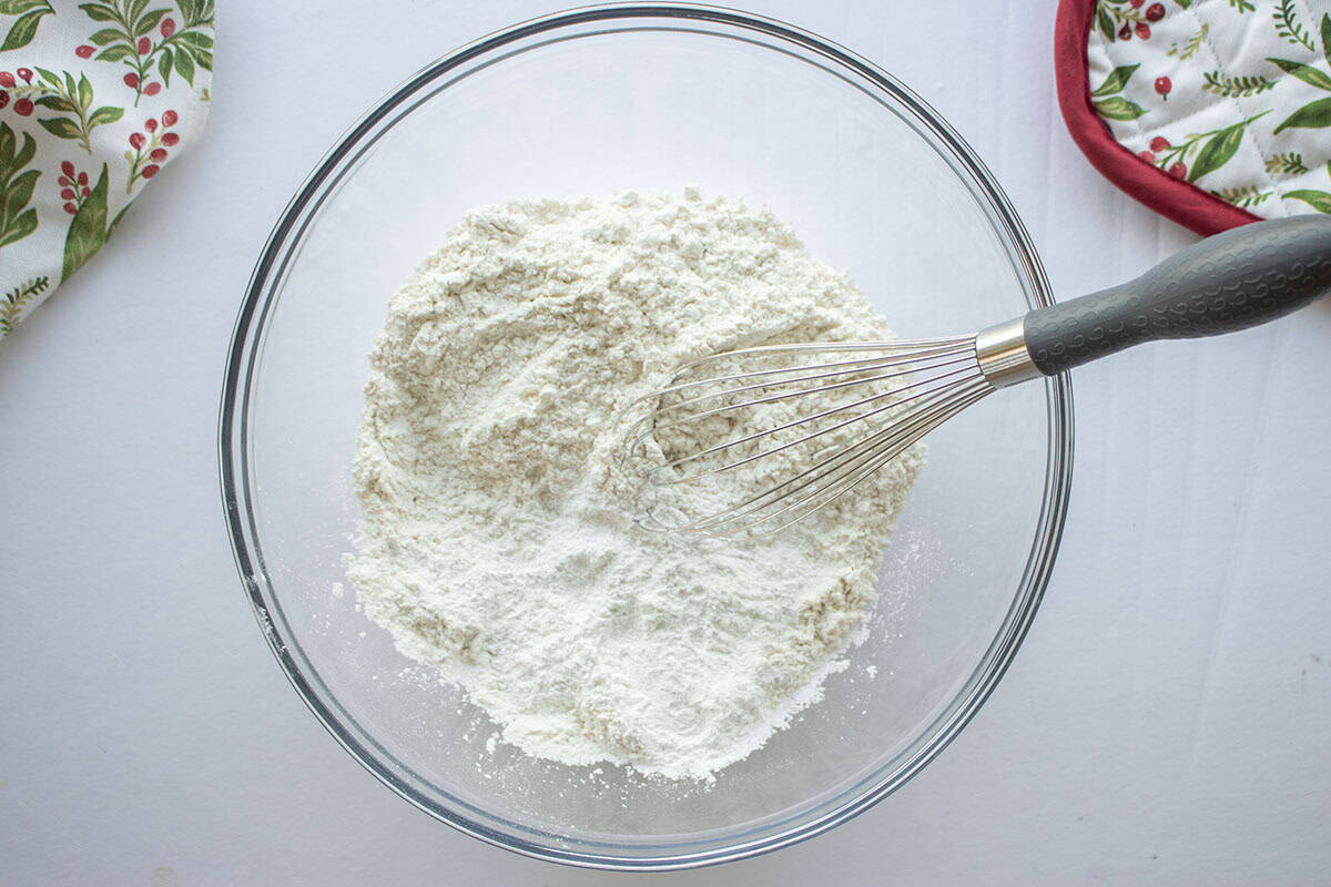 Flour, baking soda and salt in a clear mixing bowl with a whisk.