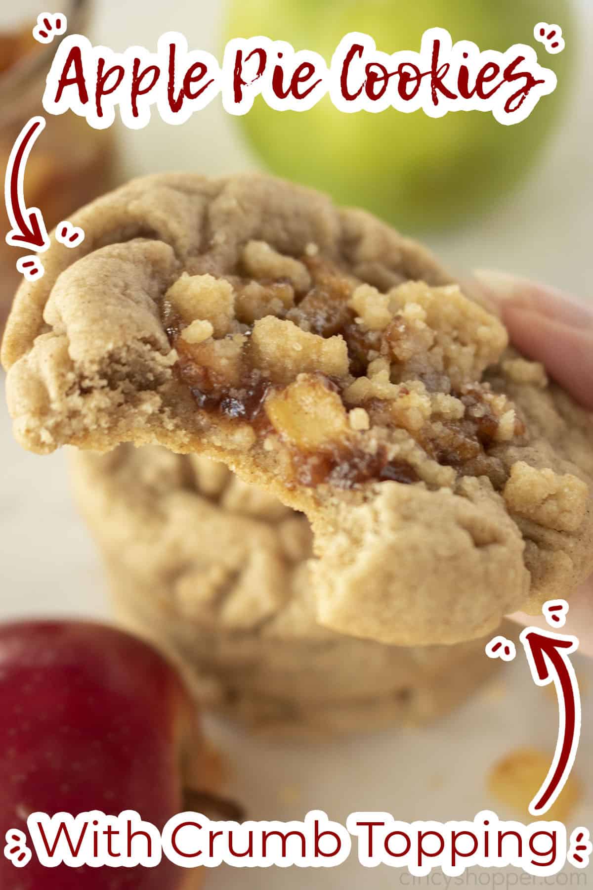 Hand holding and showing closeup of the bite taken from Apple cookie. Text on image "with crumb topping"