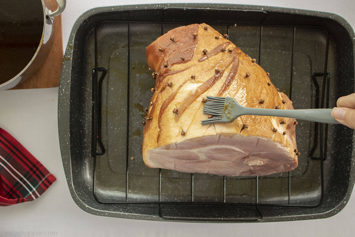 Bourbon glaze being brushed on to the top of ham shank.