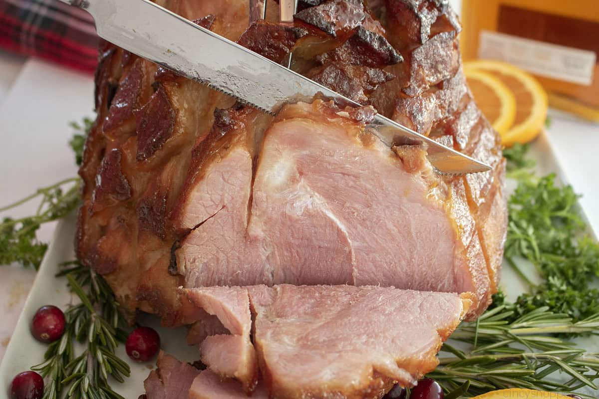 Sideways view of carving glazed ham.