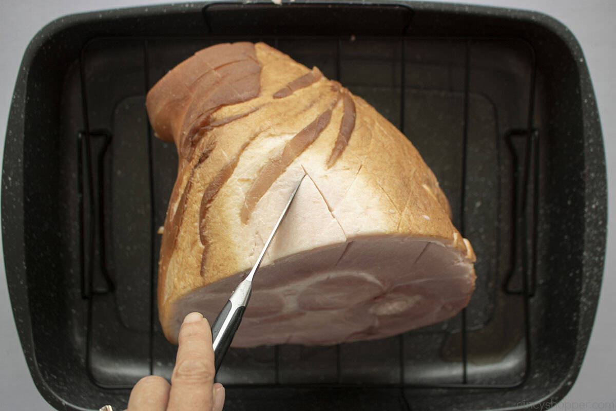 Cutting into ham to make diamond pattern.