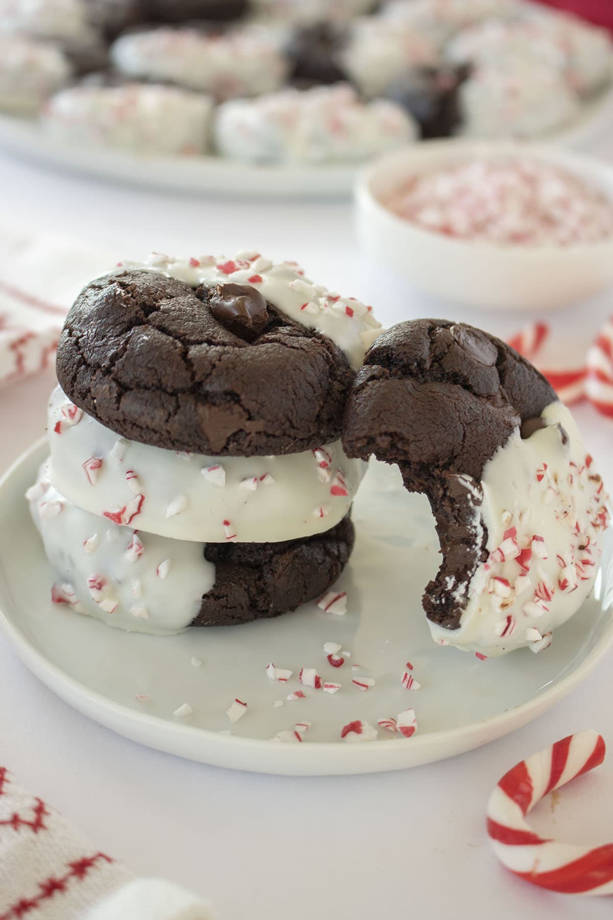 Stack of Chocolate Peppermint Cookies on a white plate with candy cane pieces.