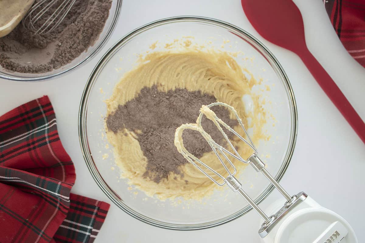 Scoop of dry ingredients added to butter mixture.