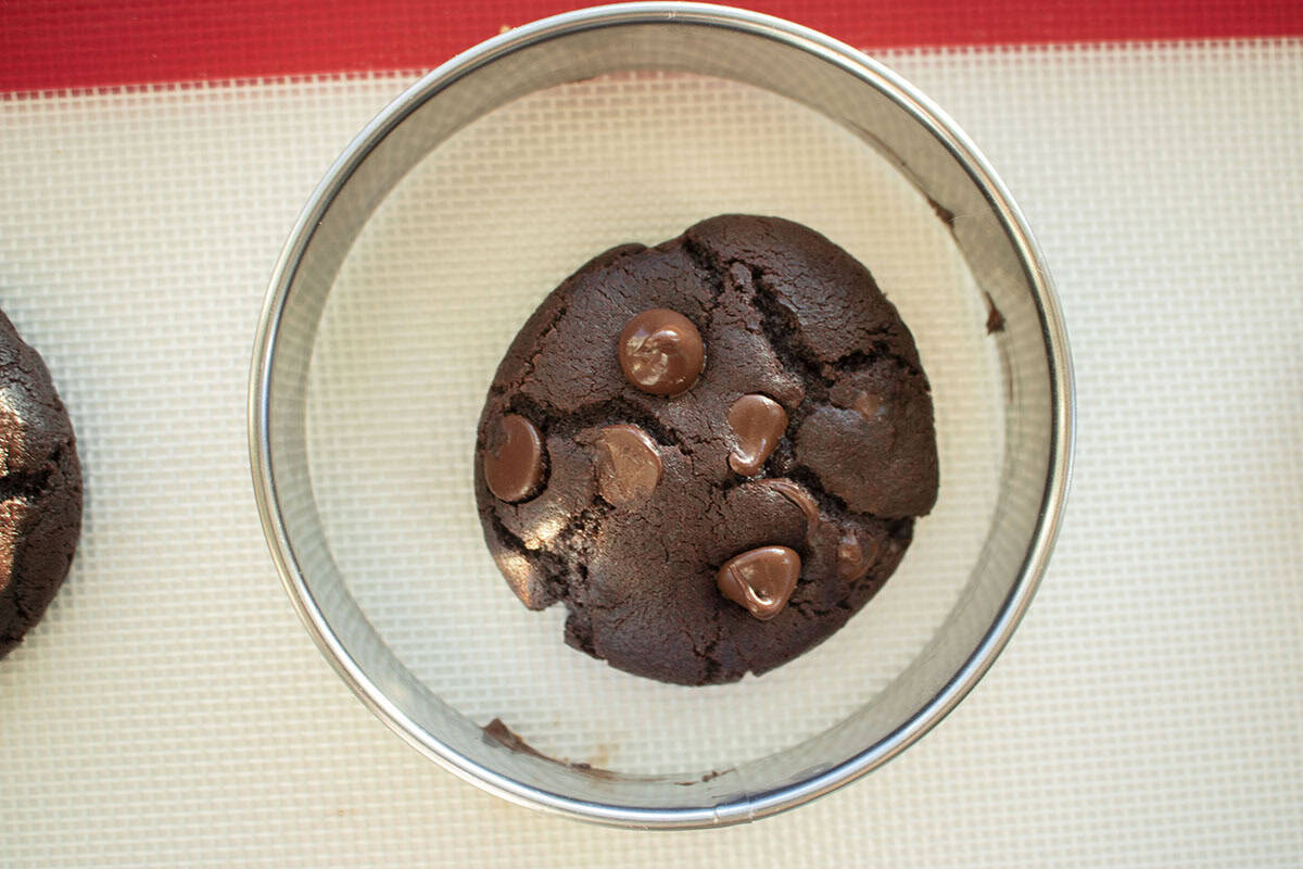 Round biscuit cutter circling fresh baked cookie.