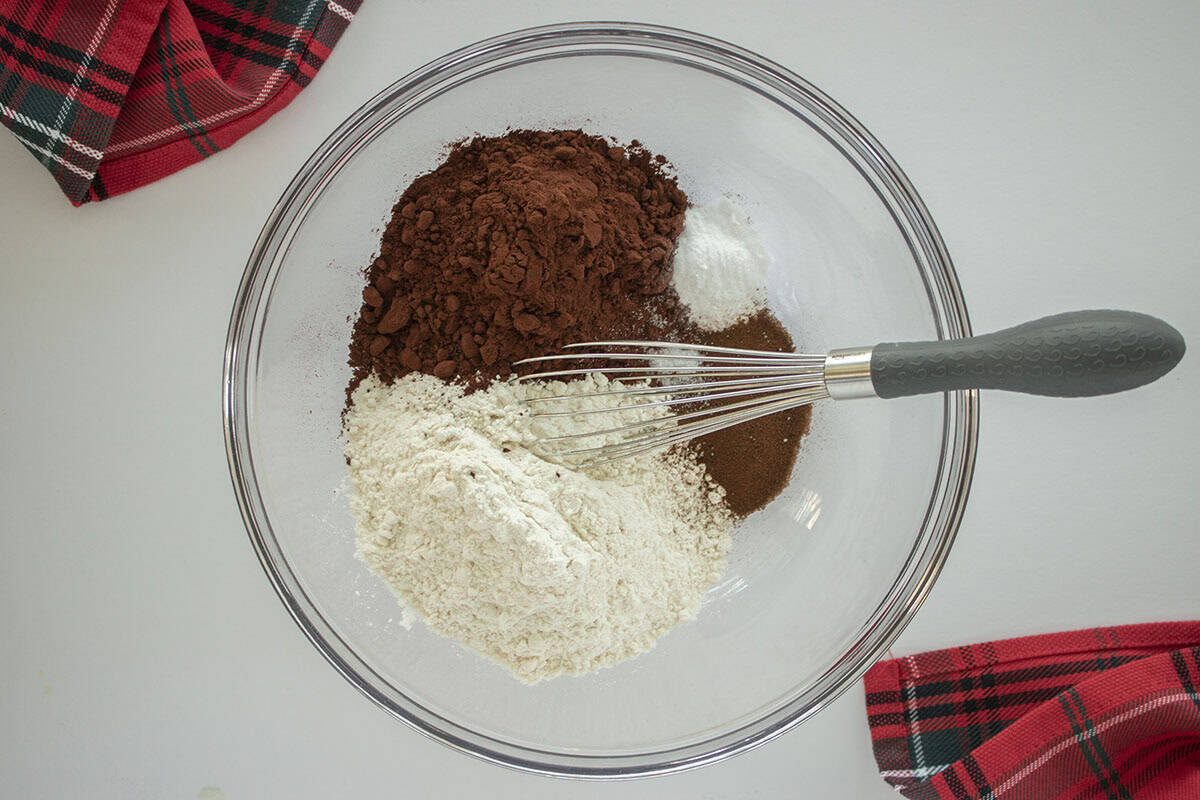 Dry cookie ingredients in a clear mixing bowl with a whisk.