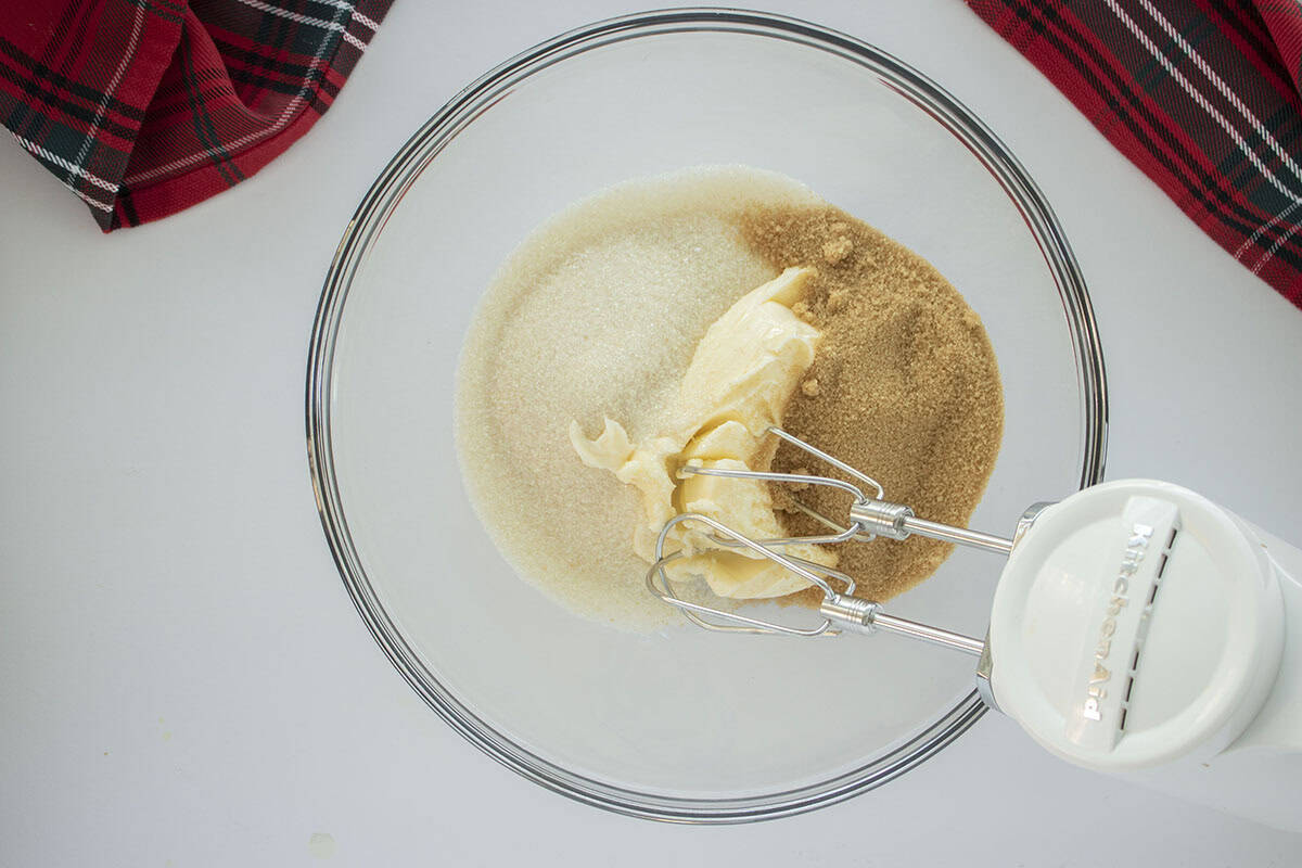 Butter and sugar in a mixing bowl with a hand mixer.