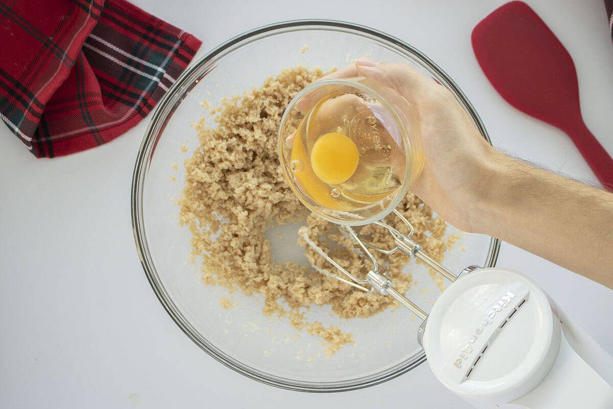 Egg being added to butter and sugar mixture.