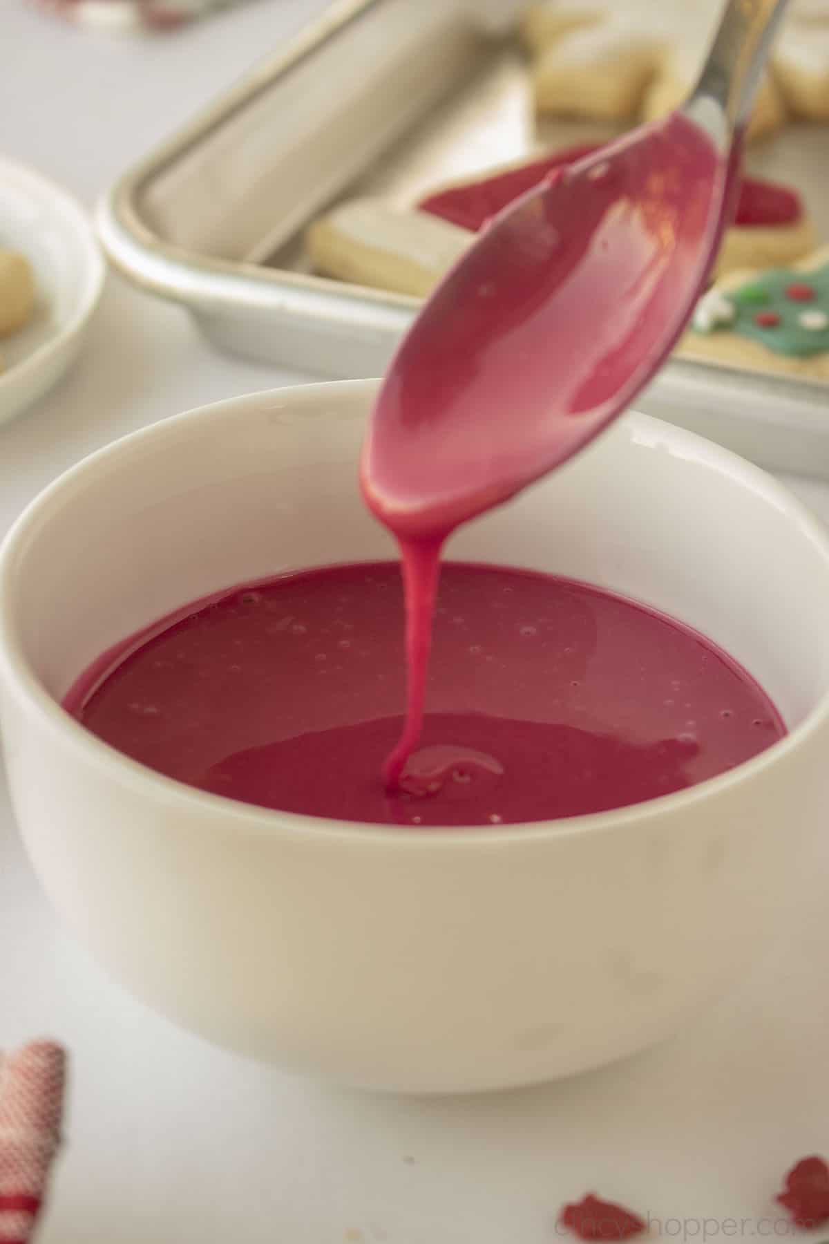Spoon with red icing for cookies that hardens.
