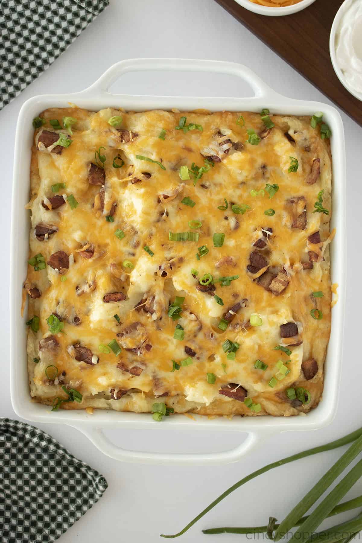 Loaded mashed potato casserole in a white dish.