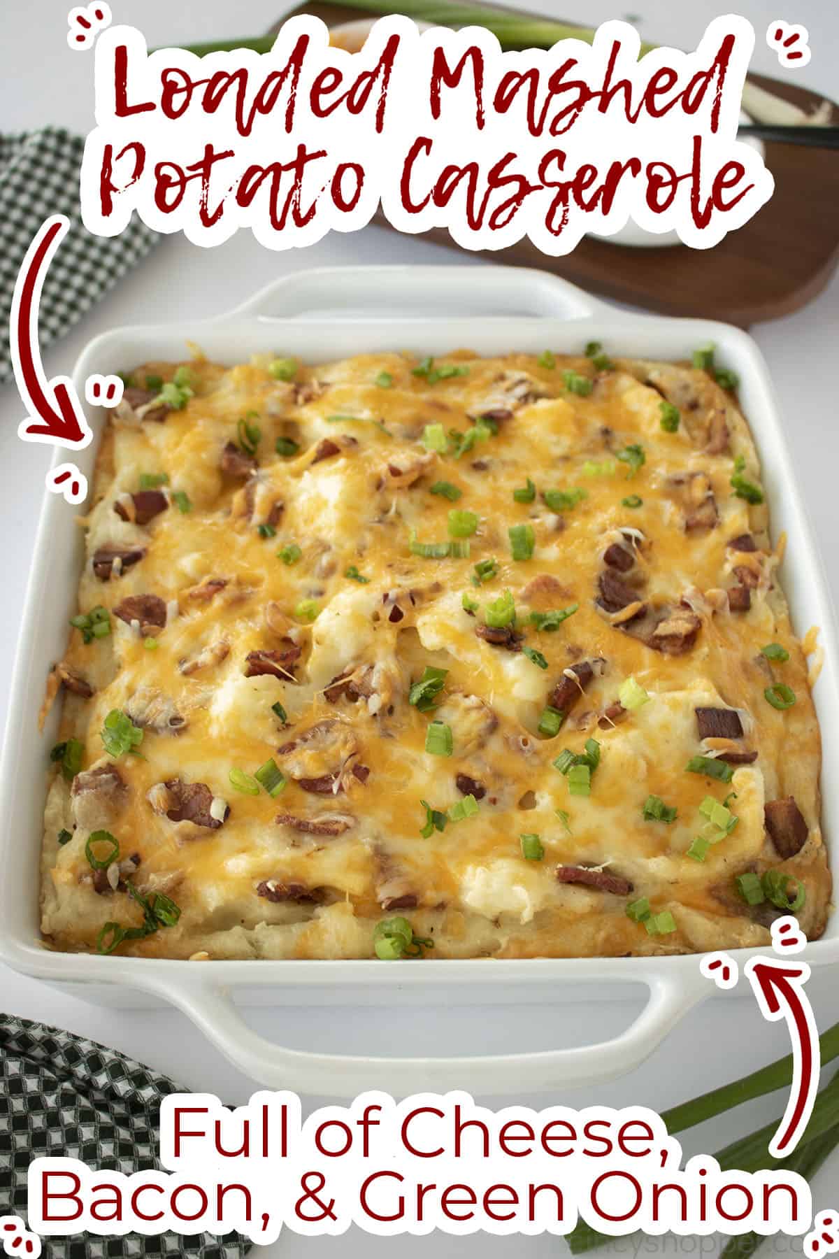 Long view of potato casserole with text on image full of cheese, bacon and green onion. 