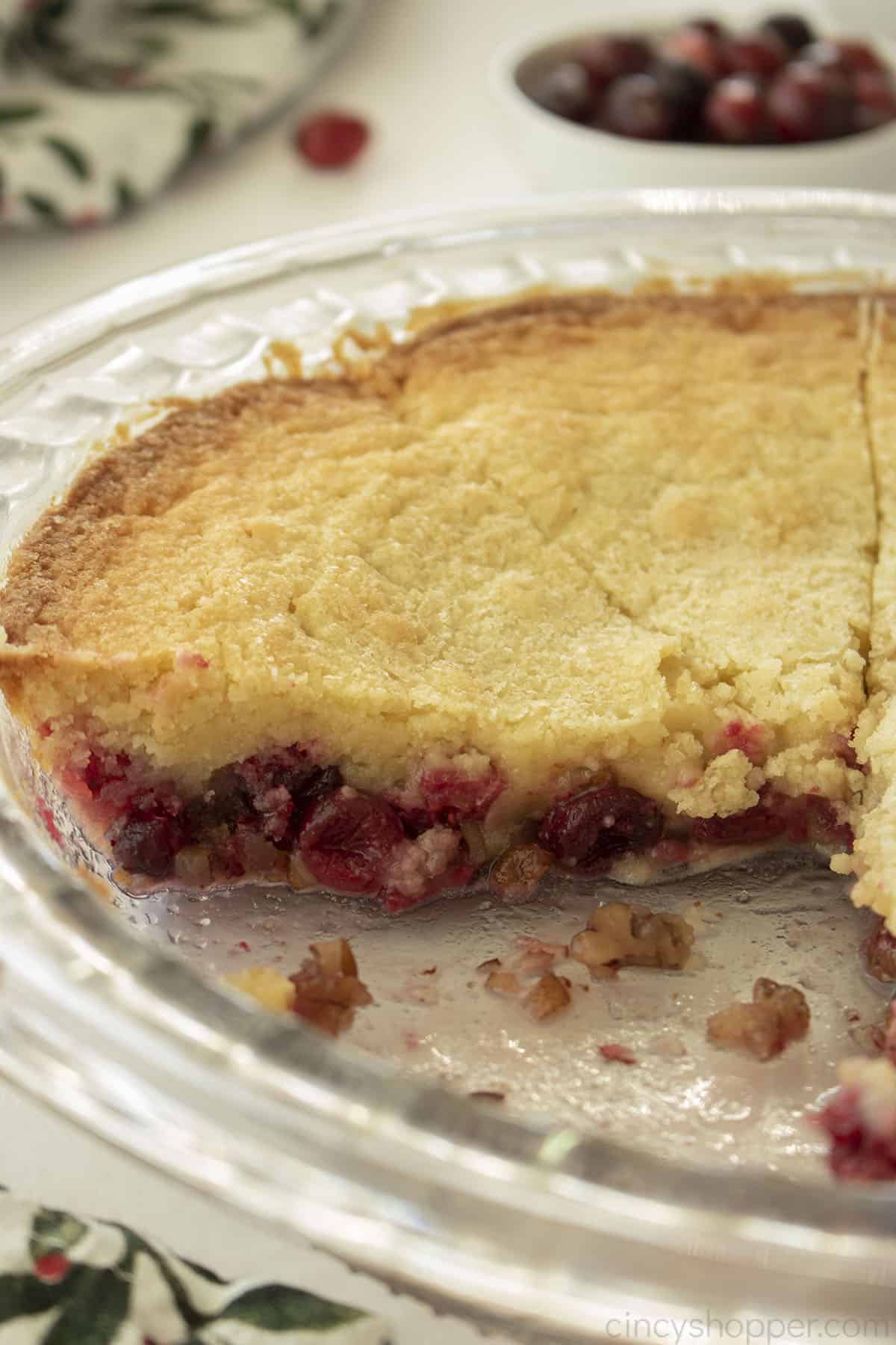 View of the side of whole Cranberry Nantucket Pie in clear pie dish.