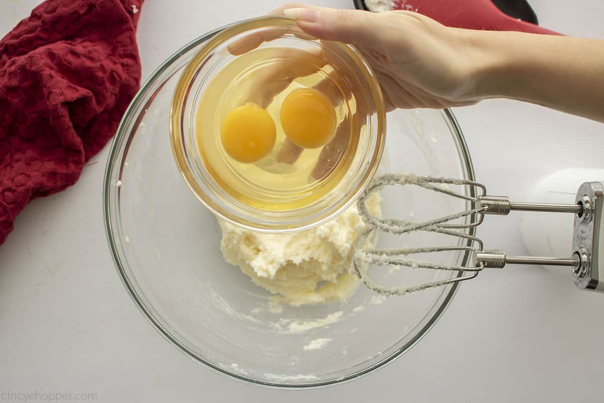Adding eggs to butter and sugar mixture.