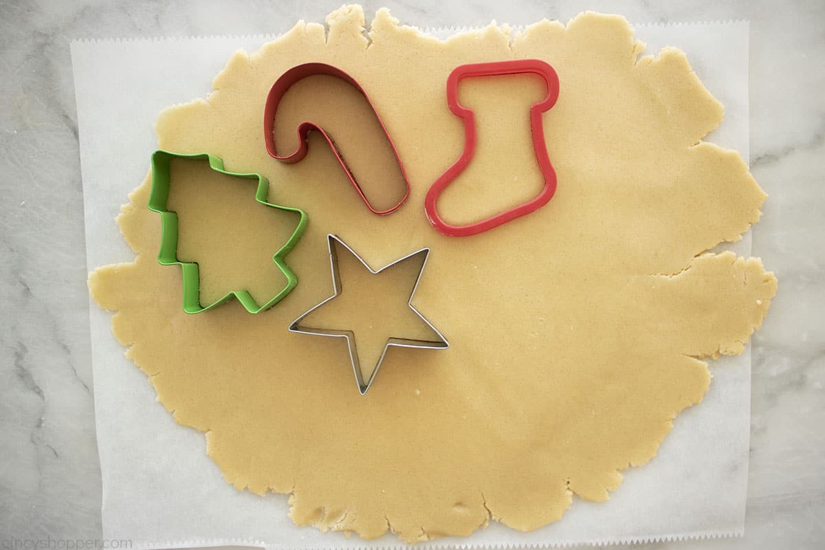 Sugar cookie dough sheet with cookie cutters making cut-out cookies.