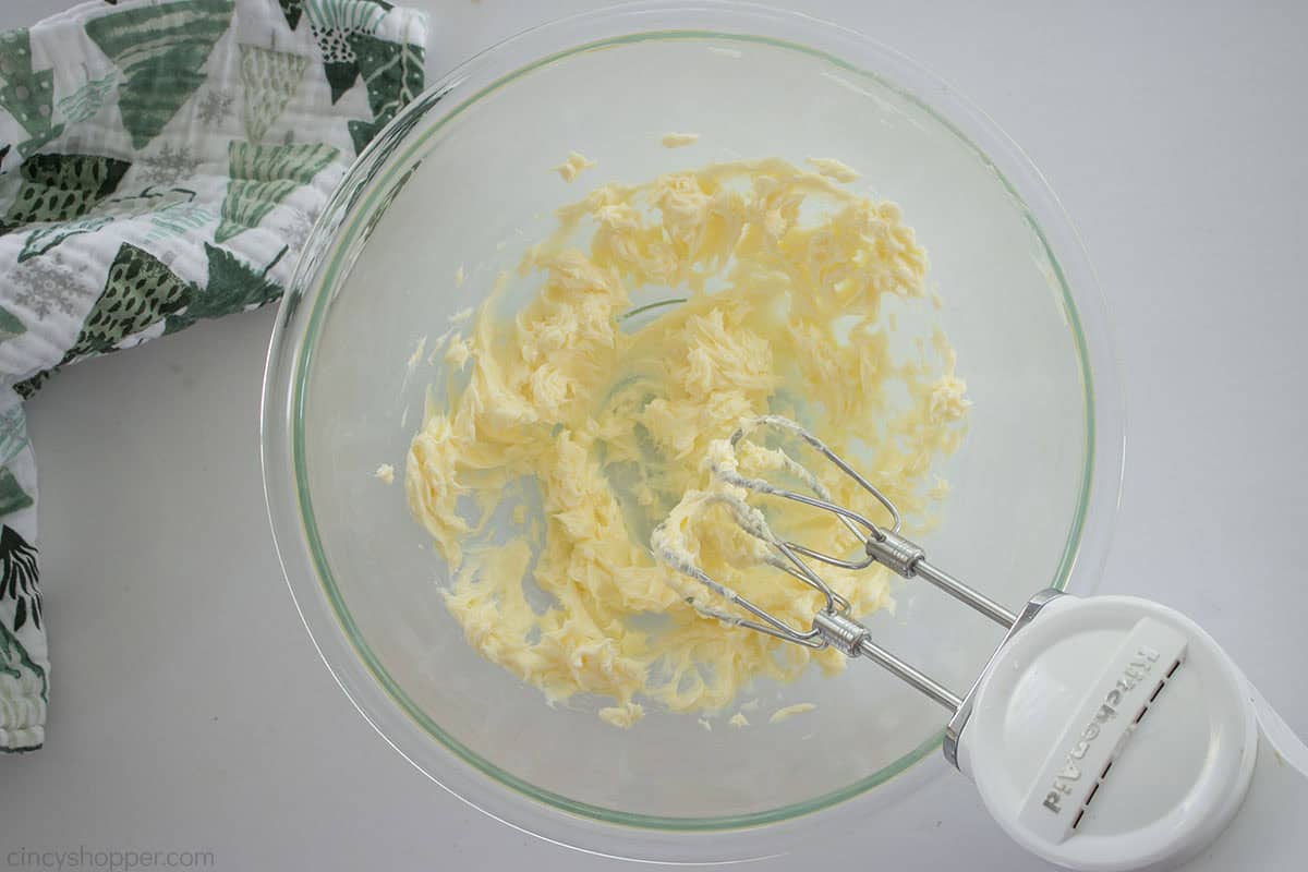 Butter creamed in a bowl with hand mixer.