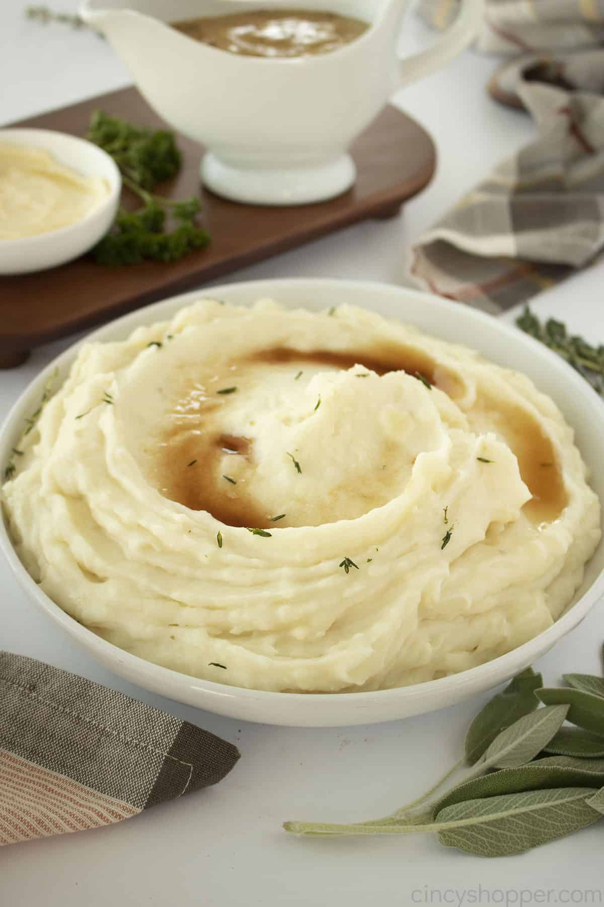 Roasted Garlic Mashed Potatoes with browned butter on top in a white bowl.