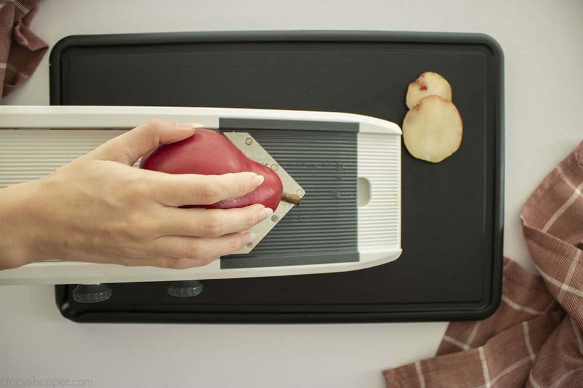 Red pear on mandoline slicer.