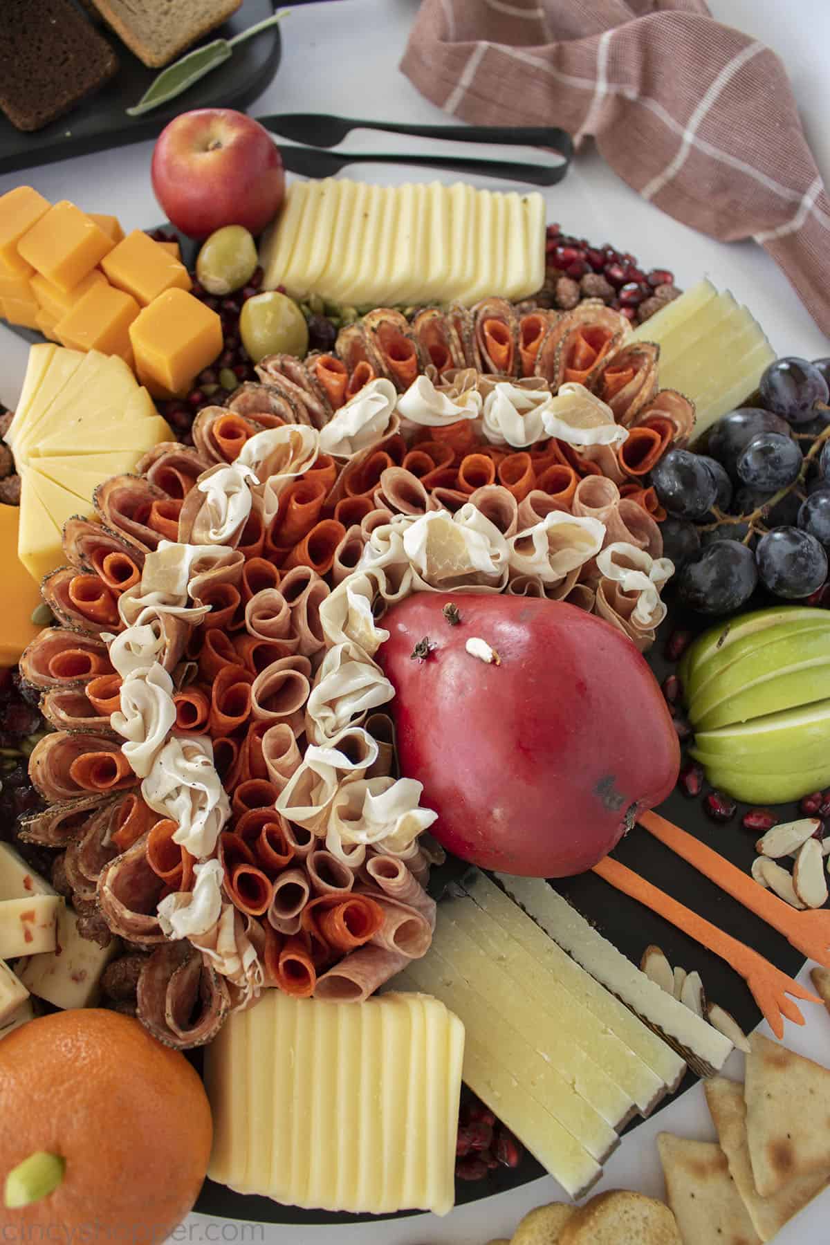 Closeup of pear turkey on a black charcuterie board for Thanksgiving.