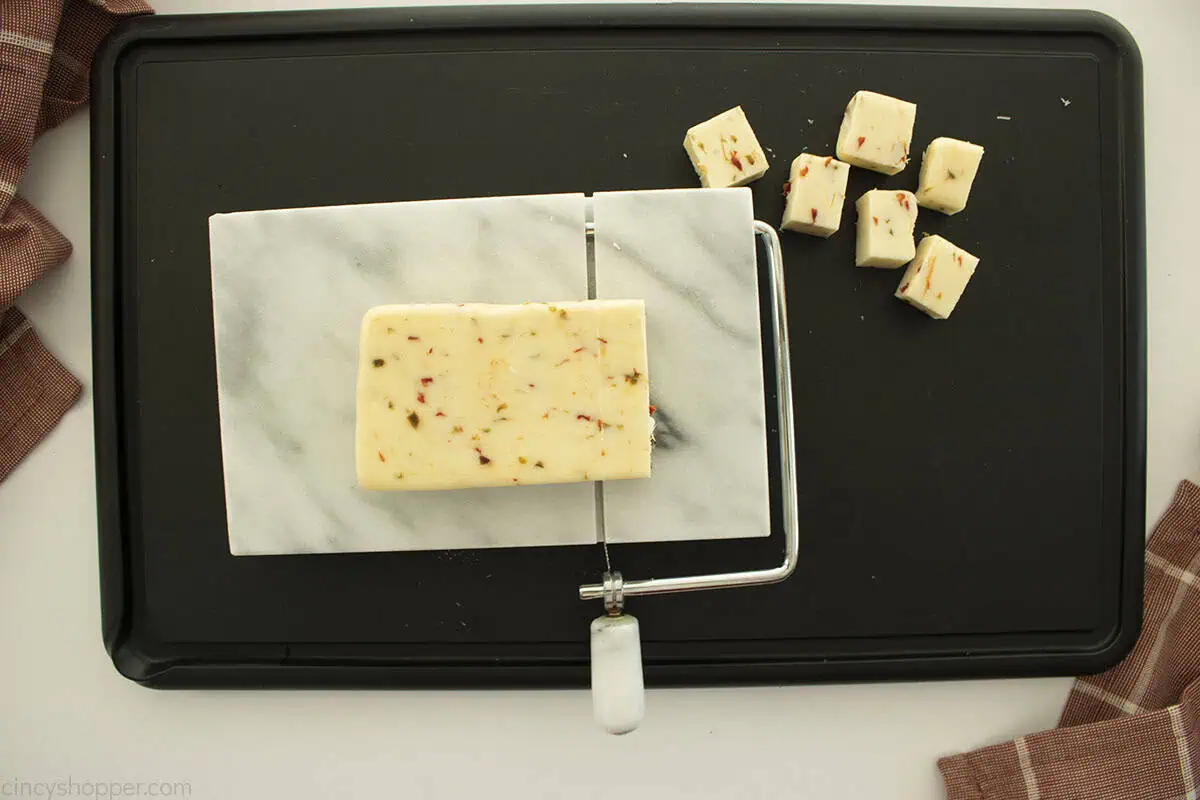 Cheese slicer with pepper jack cheese to make cheese cubes.