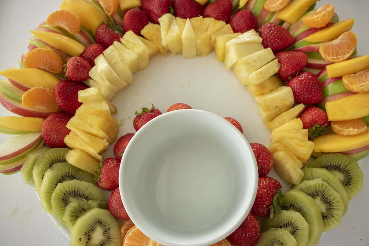 Strawberries, pineapple and kiwi placed on fruit platter for Thanksgiving.