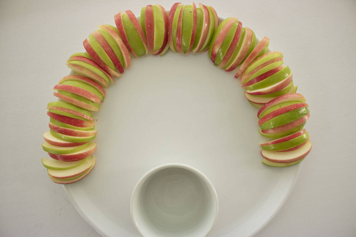 Dip bowl placed on platter as well as apple slices for feathers.