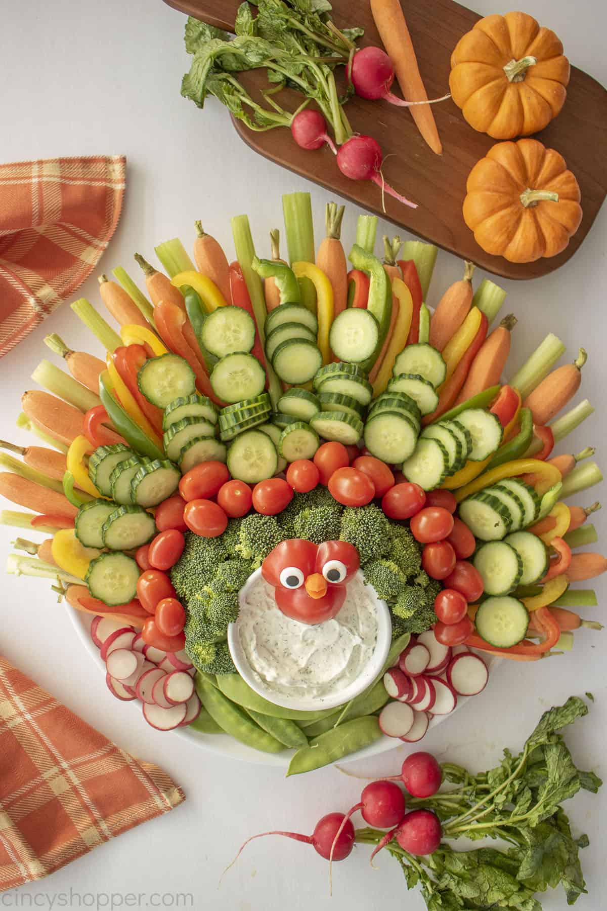 Thanksgiving Veggie Tray with a turkey face and feathers with dip on a platter.
