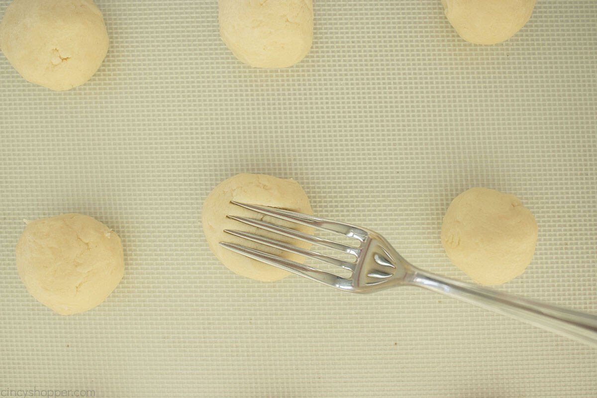 Using a fork to make indentations in cookies.