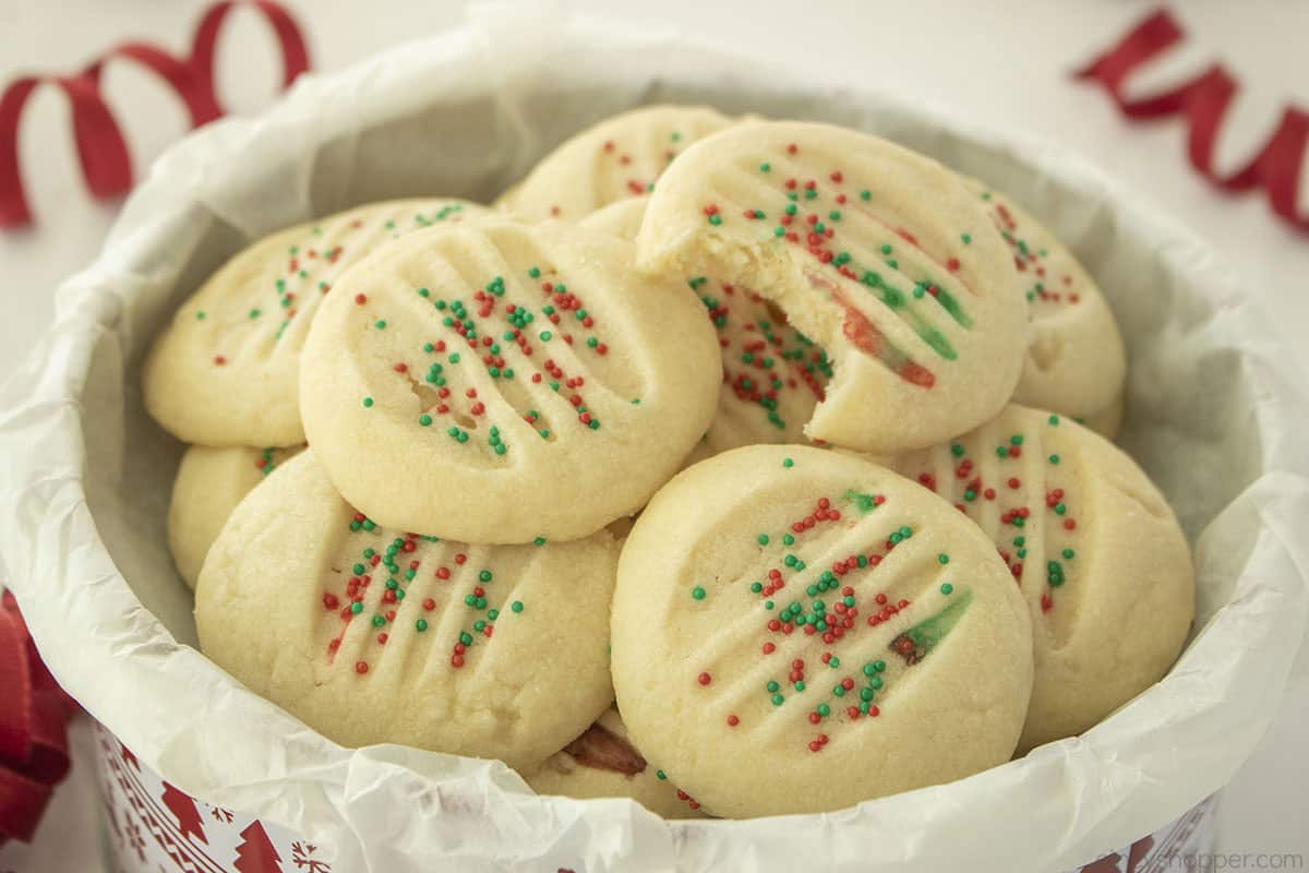 Sideways view of shortbread cookies with sprinkles in a tin.