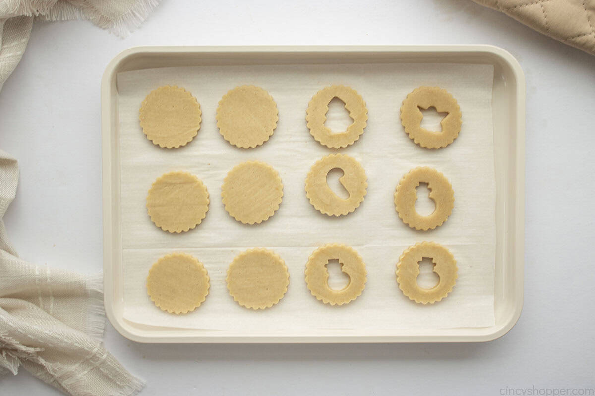 Unbaked linzers on a cookie sheet.