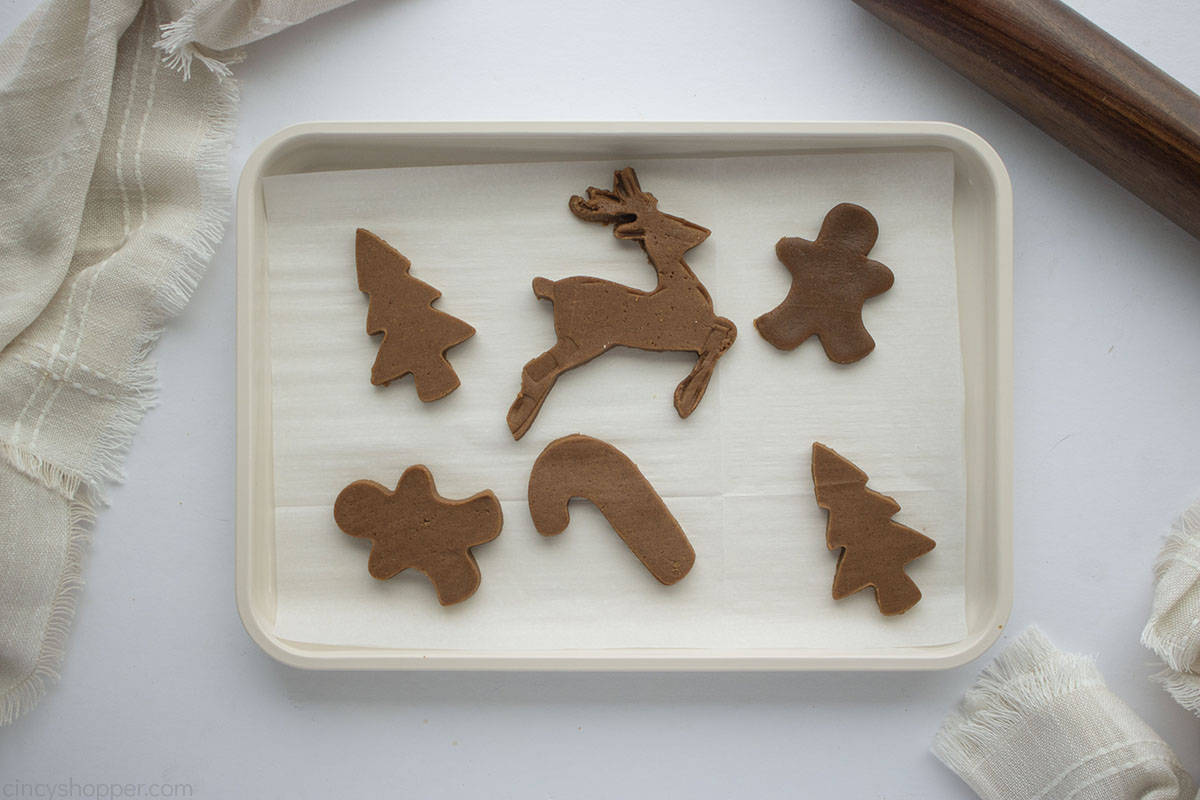 Cut out gingerbread cookies on a parchment lined baking sheet.