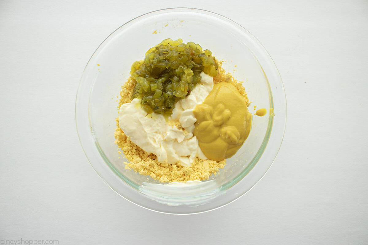 Egg mustard potato salad dressing ingredients in a bowl.