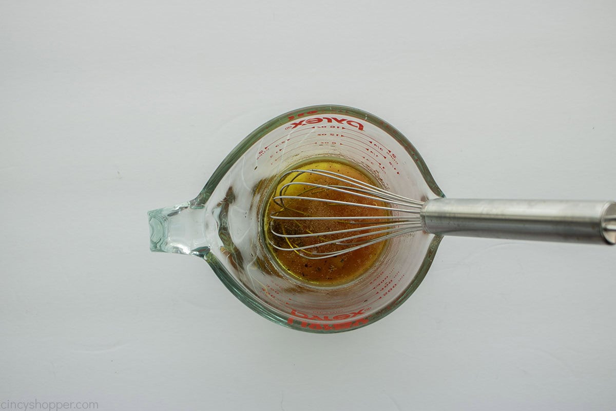 Dressing in a measuring cup with whisk.