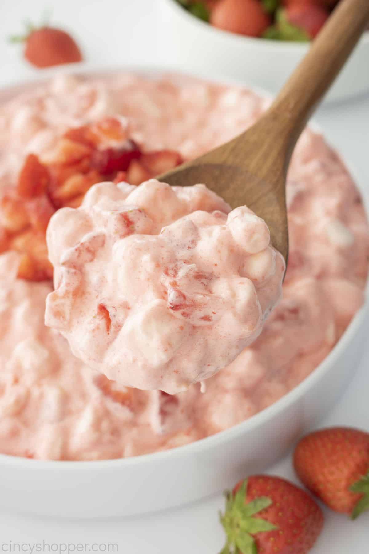 Fluffy Strawberry Salad on a wooden spoon.
