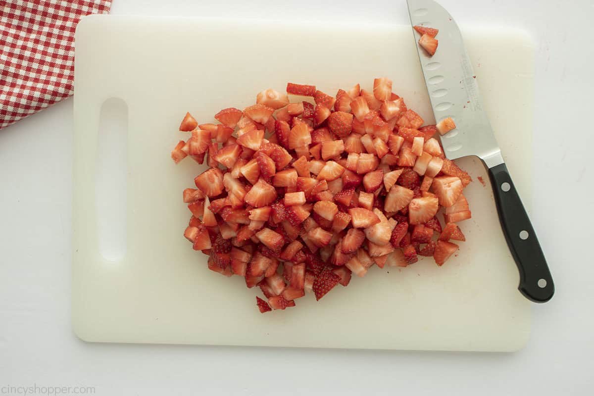 Diced strawberries on a cutting board.