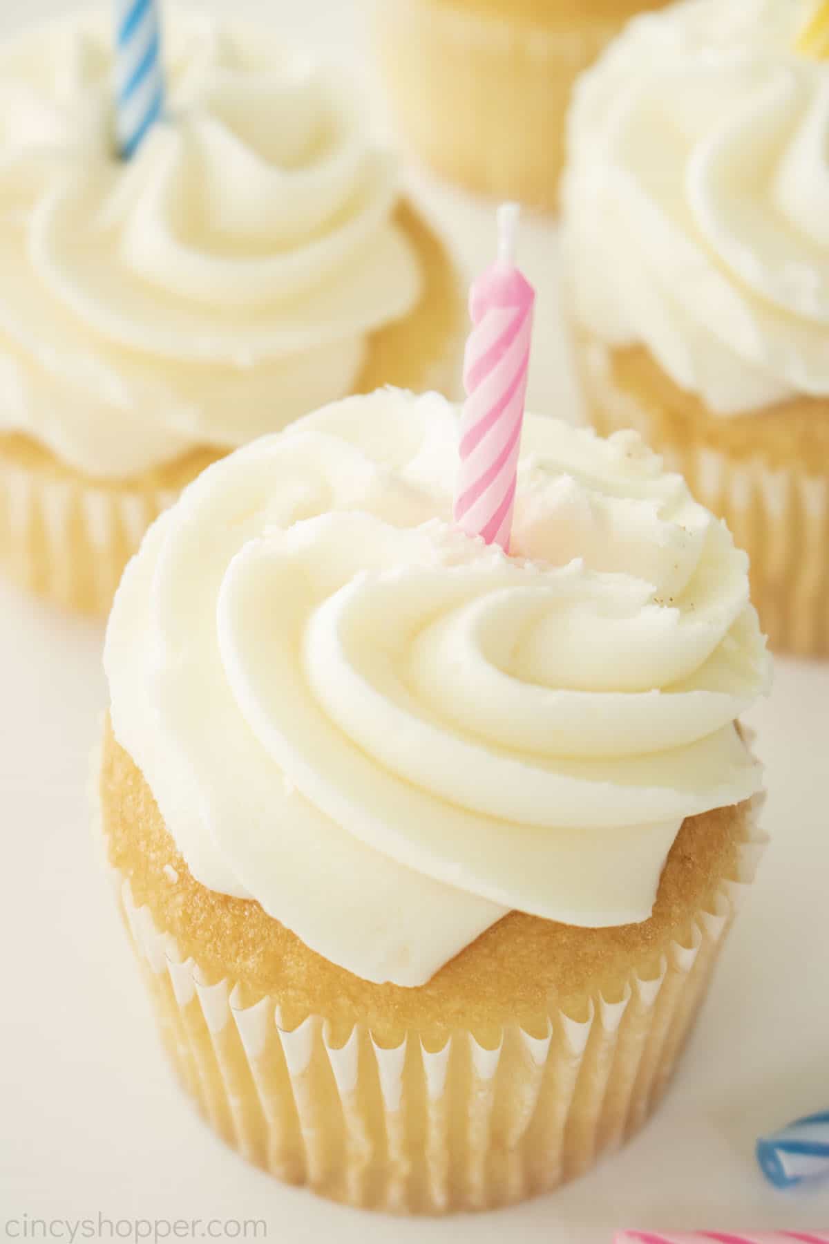 American Buttercream Frosting on a white cupcake with a birthday candle.